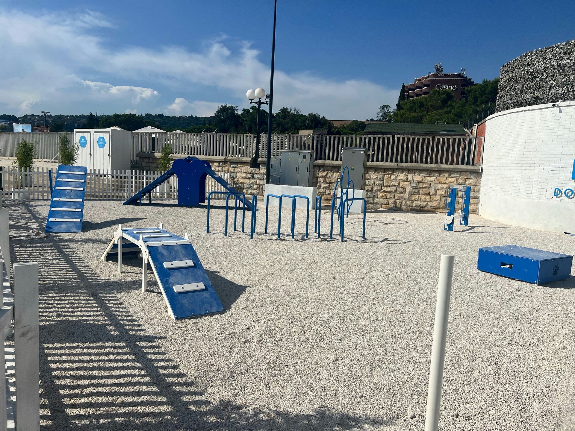 Hundespielplatz mit blauen Hindernissen und Freifläche in einer Reiseregion