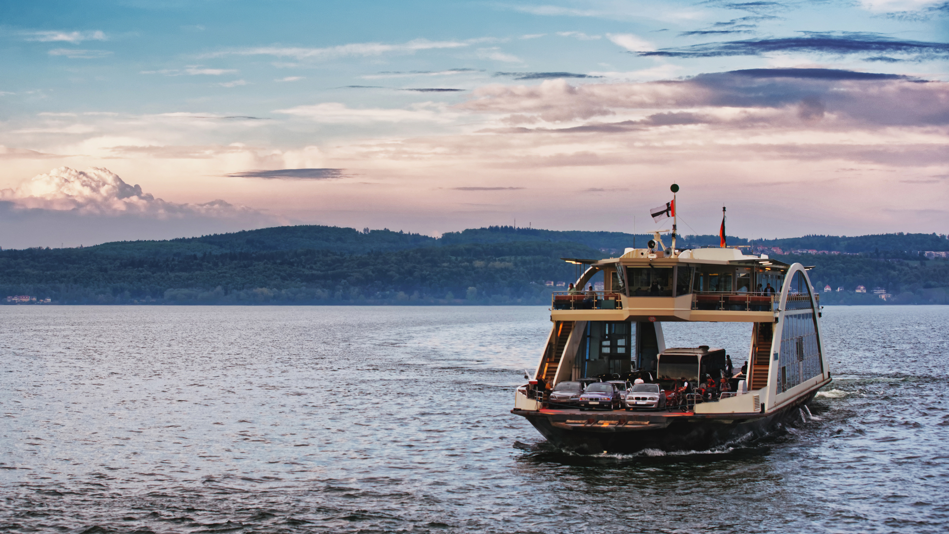 Fähre auf dem Bodensee mit Hund an Bord, Seeufer und Berge im Hintergrund