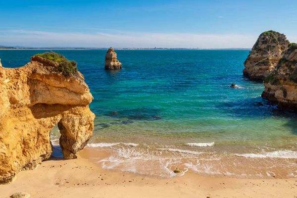 Felsformationen und klares, blaues Meer am Camilo Beach in Portugal.